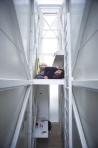 interior de la Keret House, el edificio más estrecho de Europa, con una persona acostada en el altillo