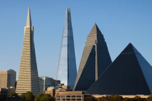 Edificios con forma de pirámide: Transamerica Pyramid, The Shard, Ryugyong Hotel y Luxor Hotel bajo un cielo azul