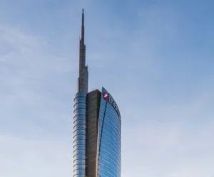 Fachada curvada de la Torre UniCredit con su pináculo iluminado, en Milán