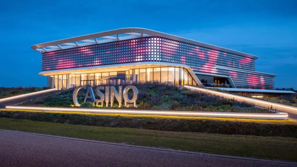 Fachada del Holland Casino Venlo iluminada por la noche con diseño LED interactivo en forma de flor
