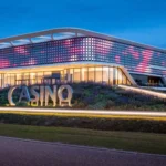 Fachada del Holland Casino Venlo iluminada por la noche con diseño LED interactivo en forma de flor