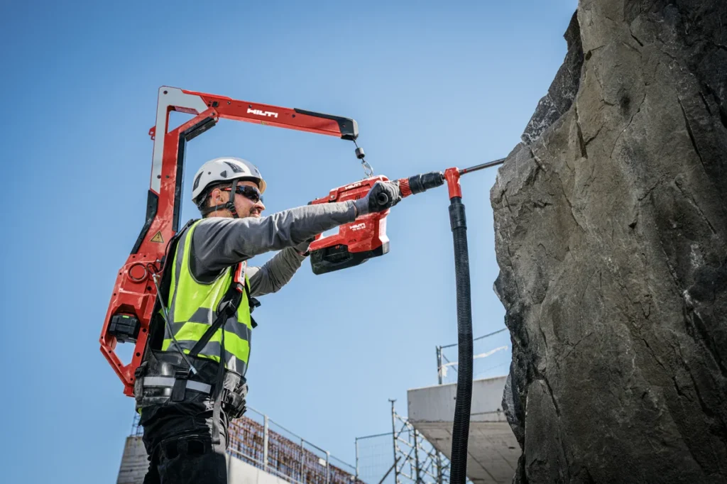 Operario usando exoesqueleto Hilti con herramienta pesada en obra