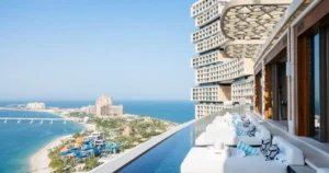 Vista diurna de la piscina infinita Cloud 22 en Atlantis The Royal con tumbonas y detalles decorativos