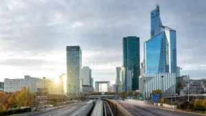 Rascacielos de La Défense en París con la Tour First iluminada por el sol del amanecer.