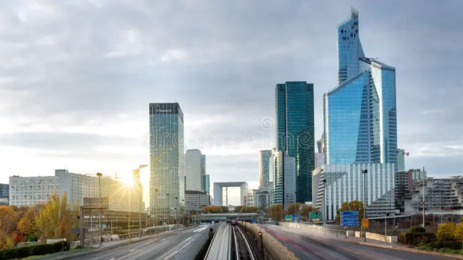 Rascacielos de La Défense en París con la Tour First iluminada por el sol del amanecer.