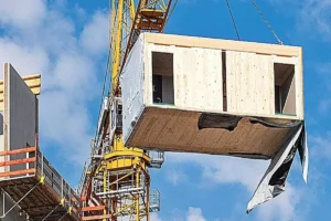 módulo prefabricado de madera técnica instalado con grúa en obra DfMA en construcción modular