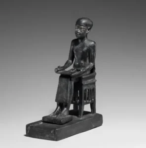 Estatua de Imhotep sentado sosteniendo papiro, escultura egipcia en bronce, dominio público.