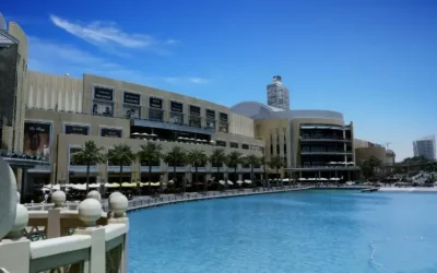 Vista panorámica del Dubai Mall con su fachada moderna y el lago artificial en primer plano