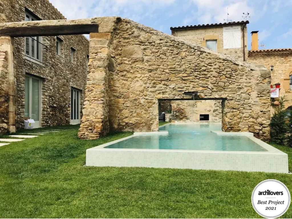 Masía antigua rehabilitada con piscina integrada en muro de piedra
