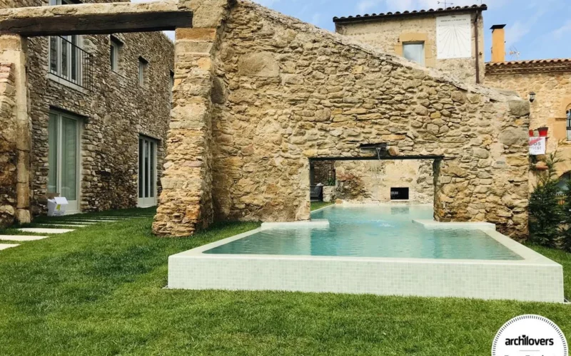 Masía antigua rehabilitada con piscina integrada en muro de piedra
