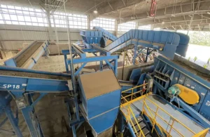 Vista interior de una planta de reciclaje de construcción con cintas transportadoras y maquinaria de clasificación