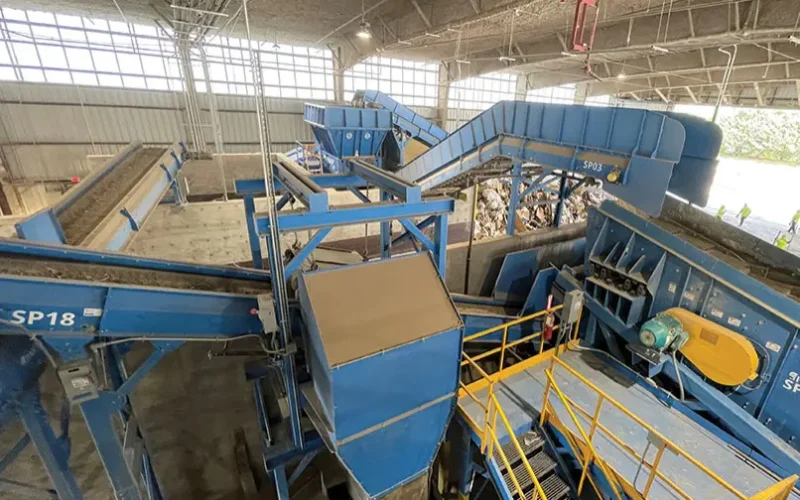 Vista interior de una planta de reciclaje de construcción con cintas transportadoras y maquinaria de clasificación