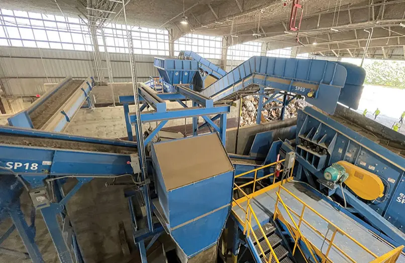 Vista interior de una planta de reciclaje de construcción con cintas transportadoras y maquinaria de clasificación