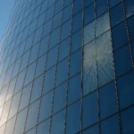 Fachada de rascacielos con panel de vidrio agrietado por choque térmico