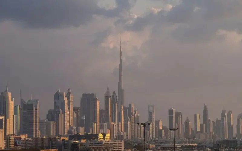 Panorámica apaisada de Dubái con el Burj Khalifa en el centro, bajo luz cálida de atardecer.