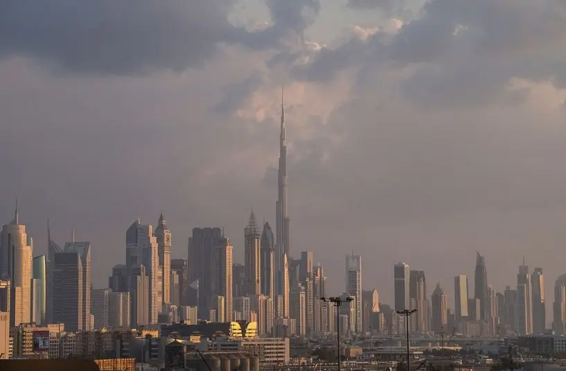 Panorámica apaisada de Dubái con el Burj Khalifa en el centro, bajo luz cálida de atardecer.