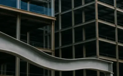 Viga metálica con pandeo frente a esqueleto estructural de edificio moderno.