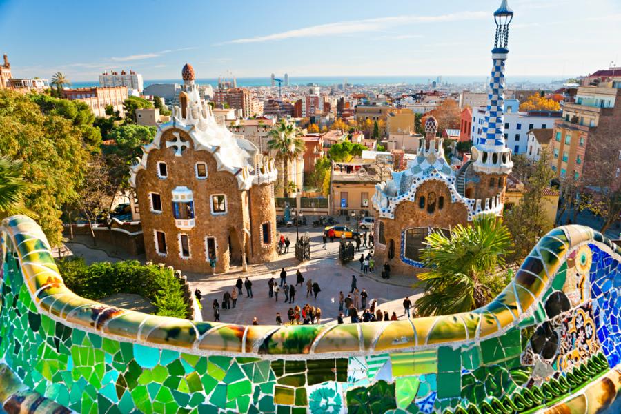 Vista panorámica del Park Güell de Gaudí desde el banco de trencadís mostrando los pabellones modernistas y la ciudad de Barcelona al fondo