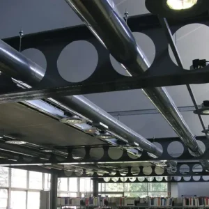 Vigas Boyd con aberturas circulares en una estructura metálica interior utilizadas en el proceso constructivo de un edificio moderno