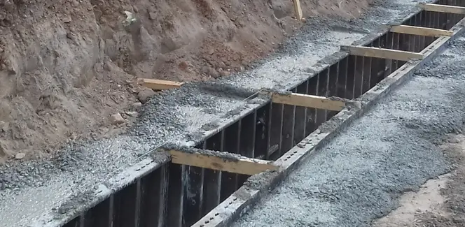 Excavación de un murete guía con encofrado metálico y hormigón fresco para muro pantalla.