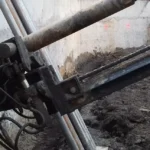 Equipo perforador realizando taladros inclinados para anclajes en un muro pantalla durante una excavación