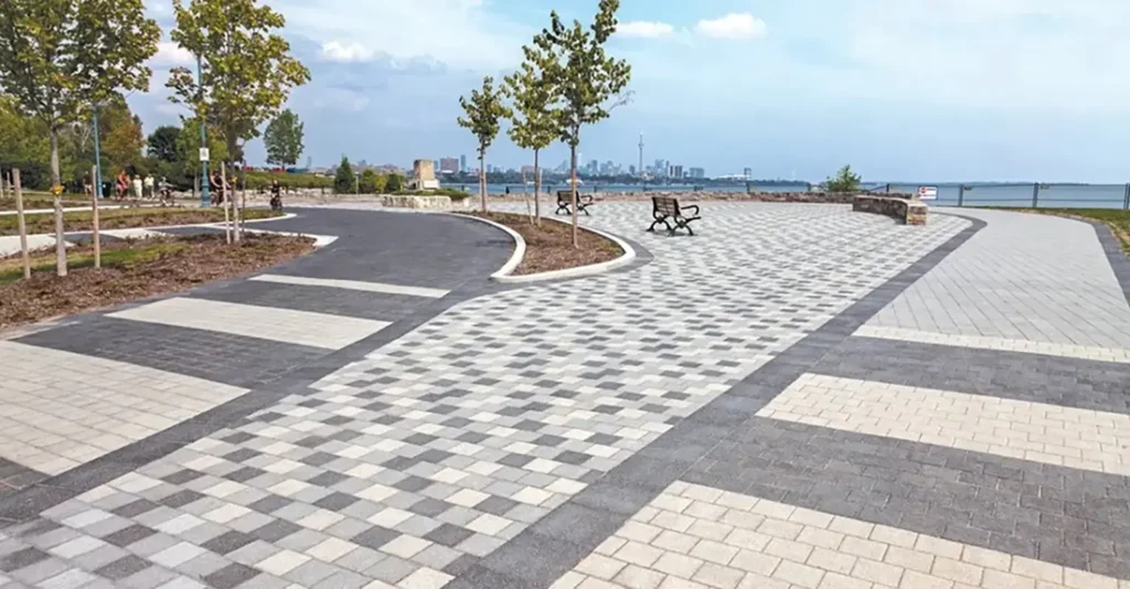 Pavimento decorativo de adoquines en tonos grises en un paseo peatonal junto al mar