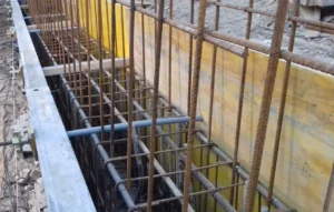 Armadura de una viga de coronación con encofrado lateral y barras de acero en un muro pantalla