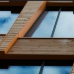 Fachada de edificio contemporáneo con estructura de madera vista y grandes superficies acristaladas