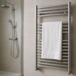 Toallero calefactable de acero inoxidable instalado en un baño moderno durante el invierno